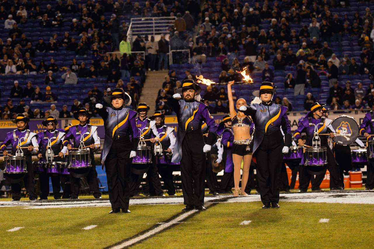Drum majors of the ECU Marching Pirates lead the band onto the field for a halftime performance
