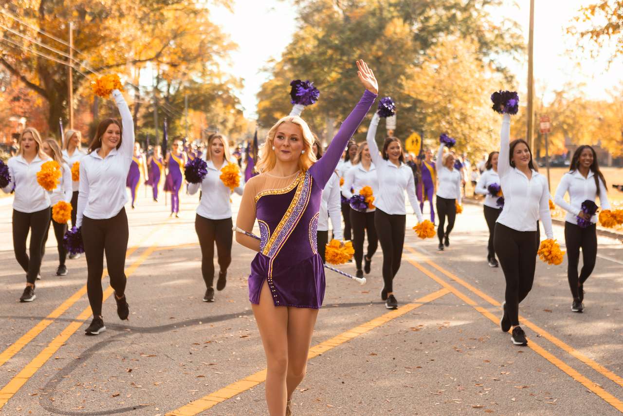 The feature twirler waves and leads the ECU Dance Team and Marching Pirates in parade.